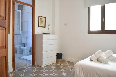 a white bedroom with a bed and a bathroom at Gran apartamento cerca de Ruzafa in Valencia