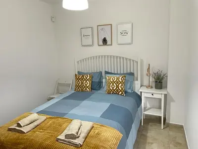 a bedroom with a blue bed with towels on it at UIM Mediterraneo PB Felipe 2 Wifi in Puerto de Sagunto