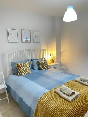 a bedroom with a blue bed with a yellow blanket at UIM Mediterraneo PB Felipe 2 Wifi in Puerto de Sagunto
