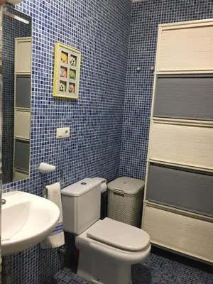 a blue tiled bathroom with a toilet and a sink at Casa buganvilla in Almarda