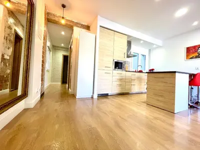a living room with a kitchen with wooden cabinets at Puerto Playa Paradise in Puerto de Sagunto
