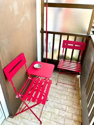 two red chairs and a table on a balcony at Puerto Playa Paradise in Puerto de Sagunto