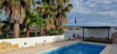 a villa with a swimming pool and palm trees at Casa Azahara your Valencian Villa in Macastre