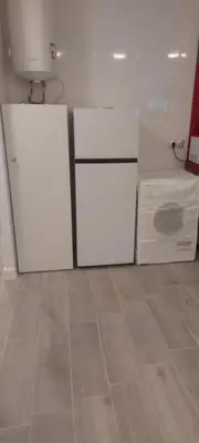 a kitchen with two white cabinets and a tile floor at Apartamento SUERTE con vistas a la playa San Antonio de Cullera in Cullera
