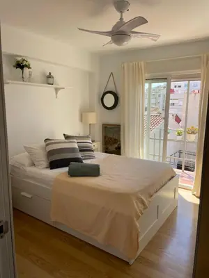 a bedroom with a large bed with a ceiling fan at La casita de Jimena in Valencia