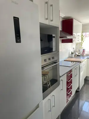 a white kitchen with a stove and a microwave at La casita de Jimena in Valencia