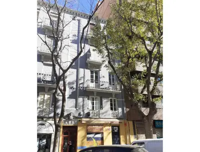 a white building on a city street with trees at Classic City Apartment in Valencia