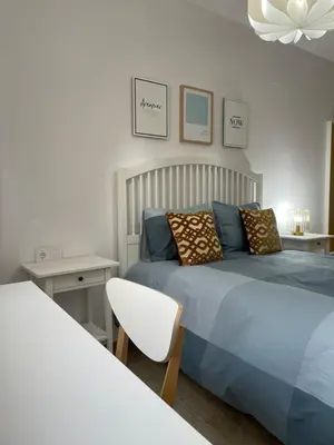 a bedroom with a blue bed and a white chair at UIM Mediterraneo ATICO Felipe Wifi in Puerto de Sagunto