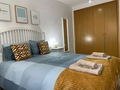 a bedroom with a large bed with towels on it at UIM Mediterraneo ATICO Felipe Wifi in Puerto de Sagunto