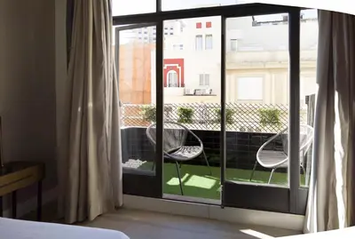 a room with a window with two chairs on a balcony at City Hall Central Market in Valencia
