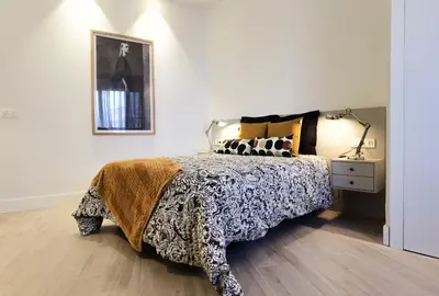 a bedroom with a bed and a lamp on a wooden floor at City Hall Central Market in Valencia