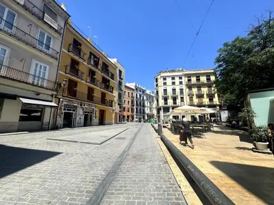 an empty street in a city with buildings at Precioso Apartamento en la Plaza del Tossal in Valencia