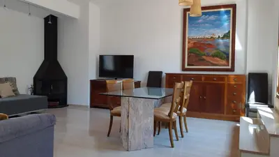 a living room with a table and a tv at Valencia Green Penthouse in Valencia
