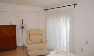a living room with a chair and a dresser at Valencia Green Penthouse in Valencia