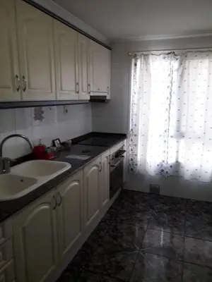 a kitchen with white cabinets and a sink and a window at Amplio piso en Sagunto in Sagunto