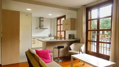 a kitchen with a couch and a table with pink pillows at Moderno Apartamento en la Plaza del Tossal in Valencia