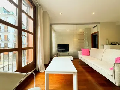 a living room with a white couch and a tv at Moderno Apartamento en la Plaza del Tossal in Valencia