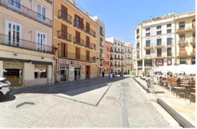 an empty street in a city with buildings at Moderno Apartamento en la Plaza del Tossal in Valencia