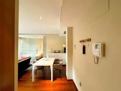 a white table and chairs in a room with a kitchen at Moderno Apartamento en la Plaza del Tossal in Valencia