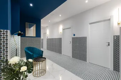 a hallway with blue walls and a blue chair and flowers at Hotelito Boutique Valencia Estación in Valencia