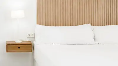 a bedroom with two white beds and a night stand at Catalina Suites Apartments Downtown Valencia in Valencia
