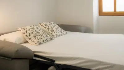 a couch with two pillows on top of it at Catalina Suites Apartments Downtown Valencia in Valencia