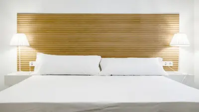 a bedroom with a large white bed with two lamps at Catalina Suites Apartments Downtown Valencia in Valencia