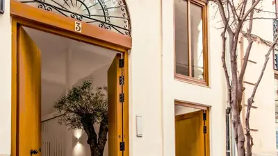 a building with a yellow door and a tree at Catalina Suites Apartments Downtown Valencia in Valencia