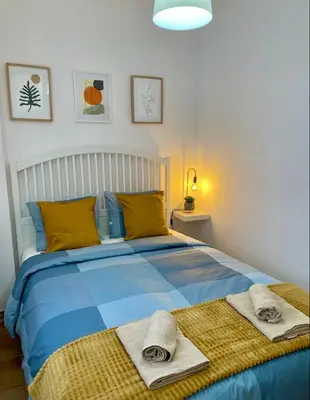 a bedroom with a blue bed with towels on it at UIM Mediterraneo PB Plomo 2 Wifi in Puerto de Sagunto