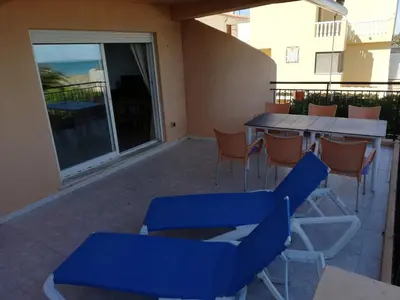 a patio with blue chairs and a table on a balcony at Oasis Solo Familias Serviplaya in Casas Las Basas