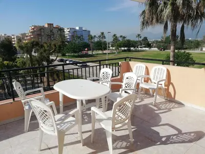 a group of white chairs and a table on a balcony at Oasis Solo Familias Serviplaya in Casas Las Basas