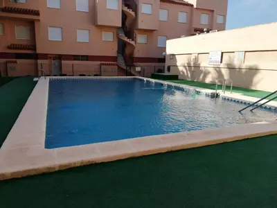 a large swimming pool in front of a building at Oasis Solo Familias Serviplaya in Casas Las Basas