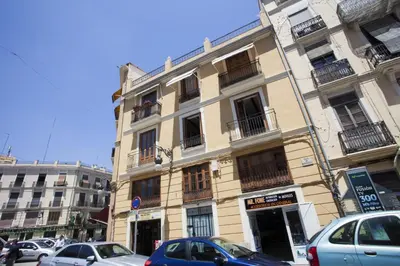 a tall building with cars parked in front of it at Singular Apartments Station in Valencia