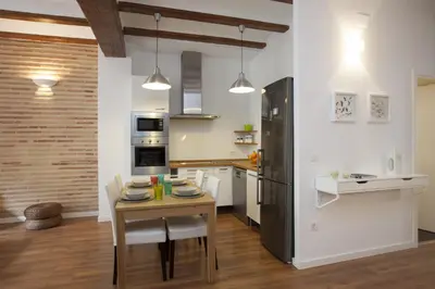 a kitchen with a table and a black refrigerator at Singular Apartments Station in Valencia