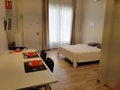 a room with a bed and a table and chairs at Studio Picasso near the port and beach in Valencia
