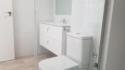 a white bathroom with a toilet and a sink at Studio Picasso near the port and beach in Valencia