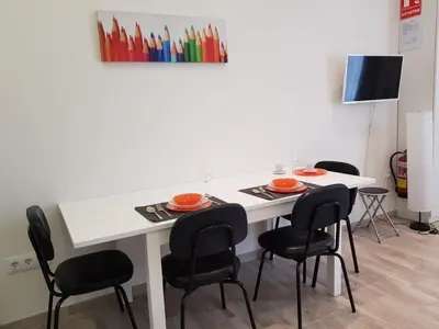 a table with four chairs and a white table with plates and bowls at Studio Picasso near the port and beach in Valencia