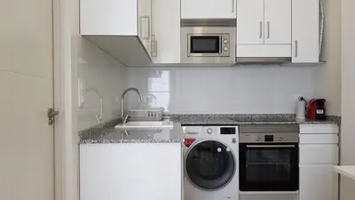 a kitchen with a washing machine and a sink at Studio Picasso near the port and beach in Valencia