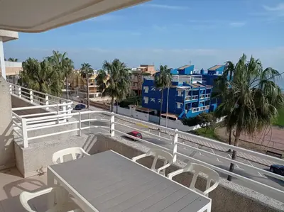 a white table and chairs and an umbrella on a balcony at Las Olas Solo Familias Serviplaya in Casas Las Basas