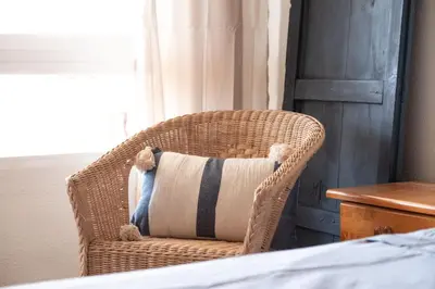 a teddy bear sitting in a wicker chair with a pillow at Las Olas Solo Familias Serviplaya in Casas Las Basas