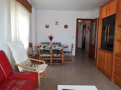 a living room with a table and chairs and a red couch at Las Olas Solo Familias Serviplaya in Casas Las Basas