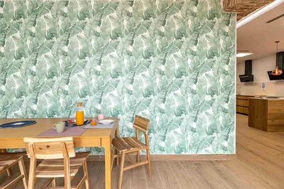 a dining room with a table and a green and white wallpaper at Residencia Demar in Godella