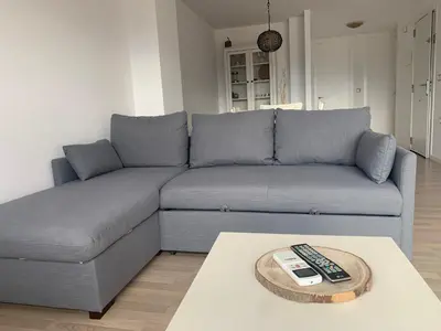 a living room with a couch with a remote control at Alojamiento en Losa del Obispo in Losa del Obispo