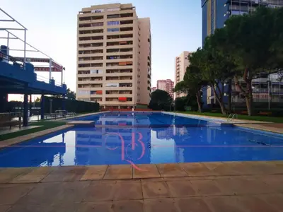 an empty swimming pool in a city with buildings at Precioso apartamento residencial con vistas al mar in Puebla de Farnals