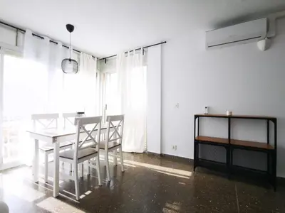 a white dining room with a table and chairs at Precioso apartamento residencial con vistas al mar in Puebla de Farnals