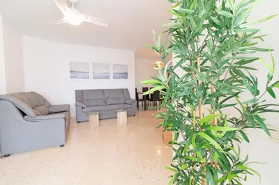 a hallway leading to a living room with a couch at Global Vacacional, Increíble apartamento en la playa, Canet d'en Berenguer in Canet de Berenguer