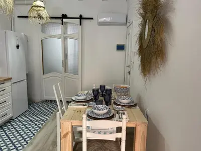 a kitchen with a wooden table and chairs and a door at Alzira bonita Loft A junto plaza mayor, la Murta in Alzira