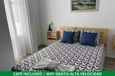 a bedroom with a large bed with blue pillows at Alzira bonita Apartamento B con patio, la Casella in Alzira
