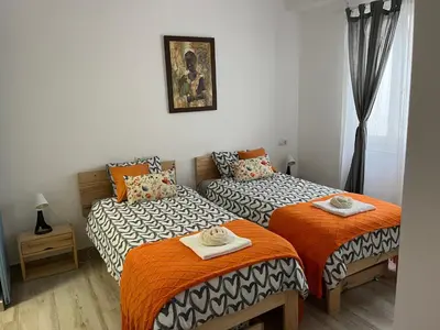 a bedroom with two beds with orange and white sheets at Alzira bonita Apartamento B con patio, la Casella in Alzira