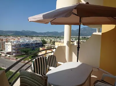 a table and chairs with an umbrella on a balcony at Les Motes Solo Familias Serviplaya!!! in Playa de Xeraco